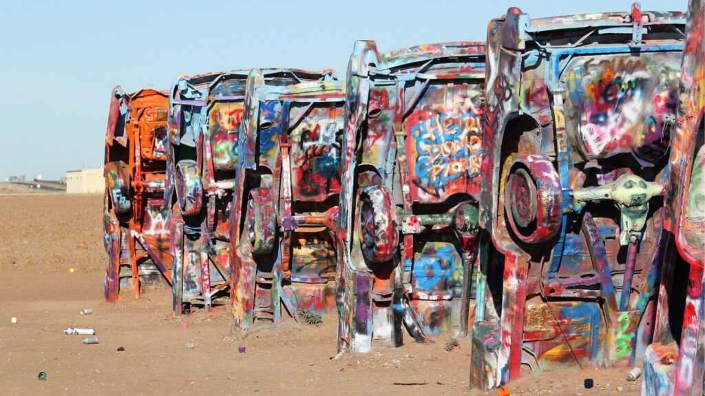 multicolored cars growing out the ground at cadillac ranch
