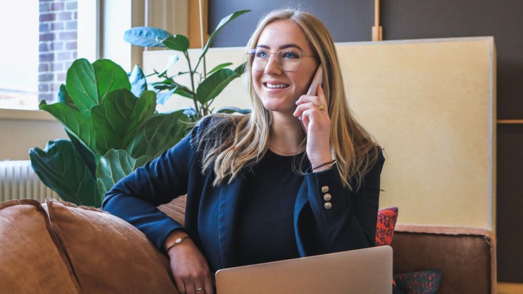 woman on phone sitting with laptop